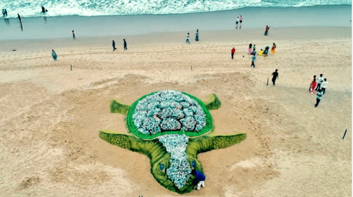 Una gigantesca tartaruga costruita sulla spiaggia con migliaia di bottiglie di plastica